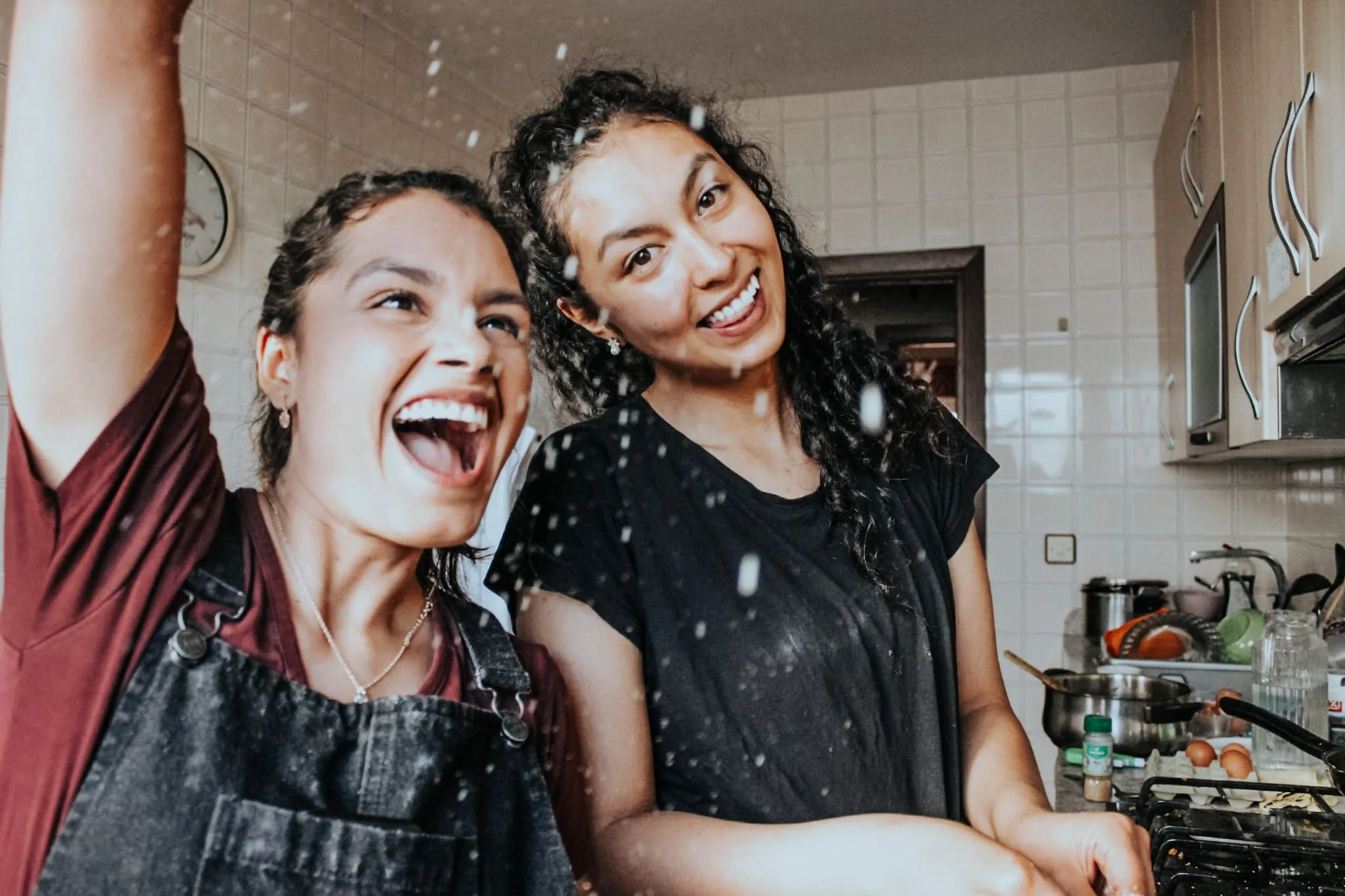 Dos jóvenes riendo bajo la lluvia en una actividad de la iglesia