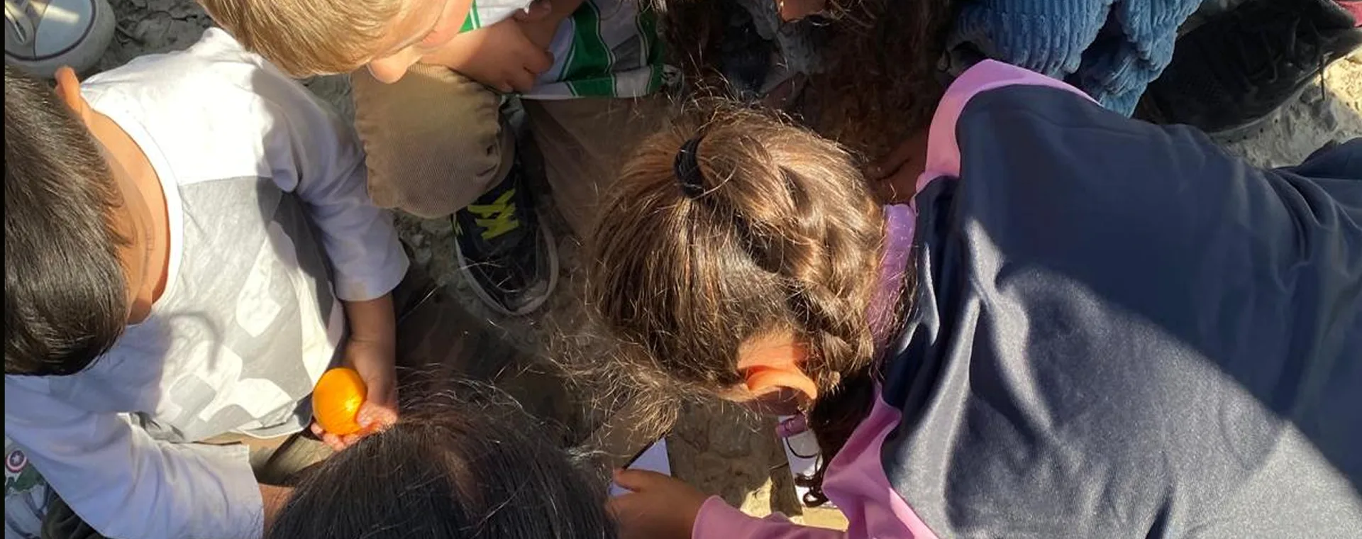 Niños haciendo manualidades alrededor de una mesa