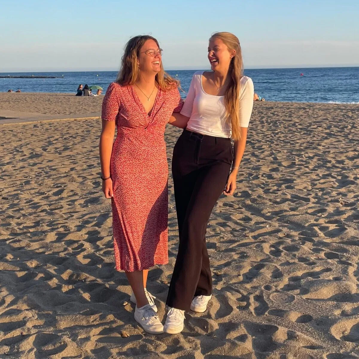 Dos voluntarias en la playa al atardecer