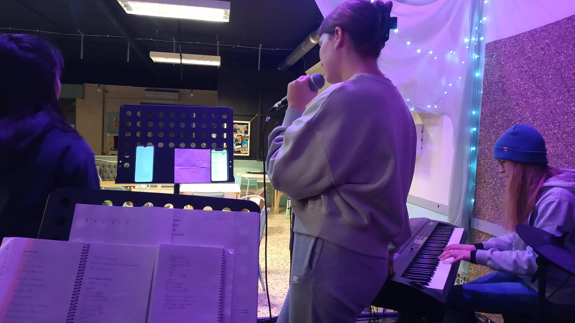 Ensayo del equipo de alabanza con luces moradas y teclado